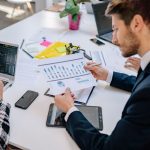 Business team reviewing graphs and data in an office setting. — Key Responsibilities of a Public Affairs Officer in the Press