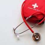 A red first aid kit paired with a stethoscope, signifying healthcare and medical treatment essentials. — Stuart Piltch Helps